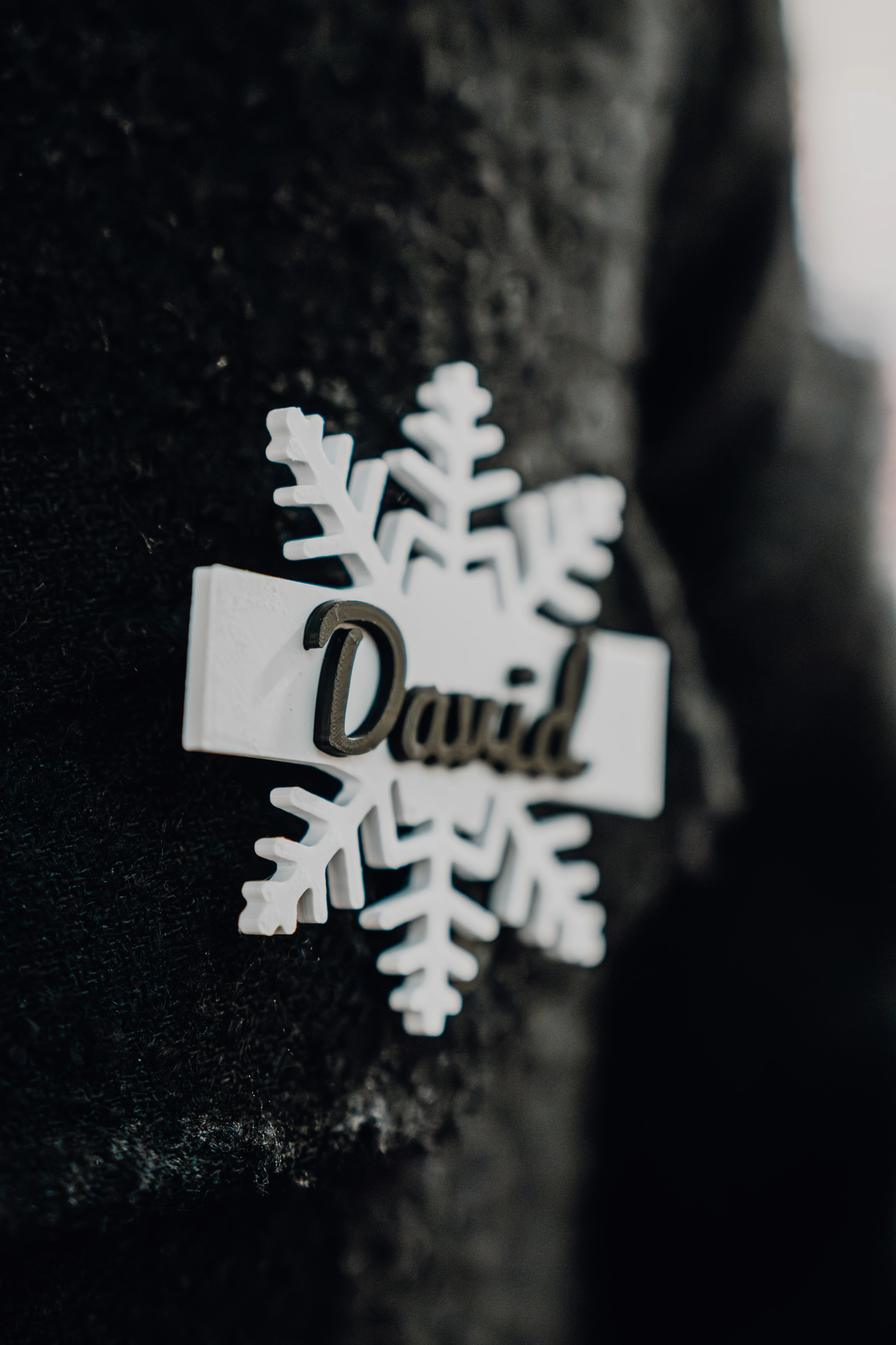 Nahaufnahme des Namensschilds in Schneeflockenform mit dem Namen David.